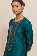 Teal green silk straight short kurta set with hand-embroidered sequins at the neck, borders running along the hem and sleeve edges, and scattered gold sequins embellishments all-over.
