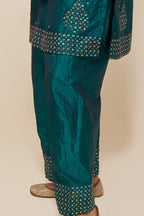 Teal green silk straight short kurta set with hand-embroidered sequins at the neck, borders running along the hem and sleeve edges, and scattered gold sequins embellishments all-over.