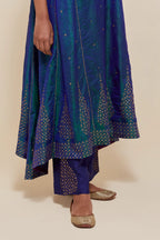 Teal blue silk kurta set with asymmetric hem and hand-embroidered leaf motifs with delicate sequins work at the neck, sleeves, and hem, with sequins border running along the edges.