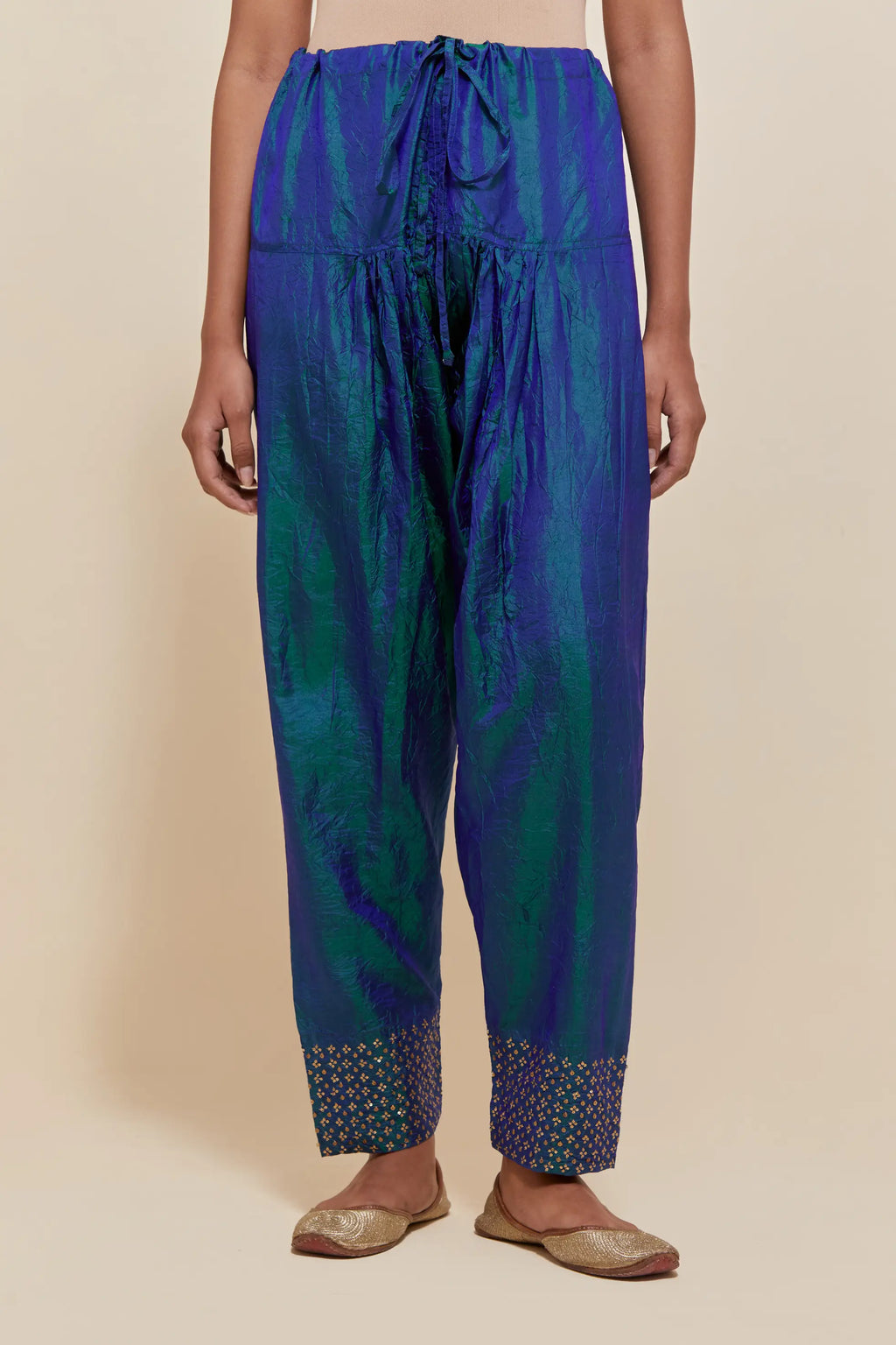 Teal blue silk salwar with hand-embroidered gold sequin work in a broad border at the hem.