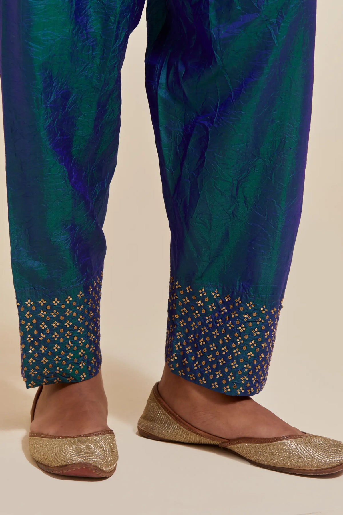 Teal blue silk salwar with hand-embroidered gold sequin work in a broad border at the hem.