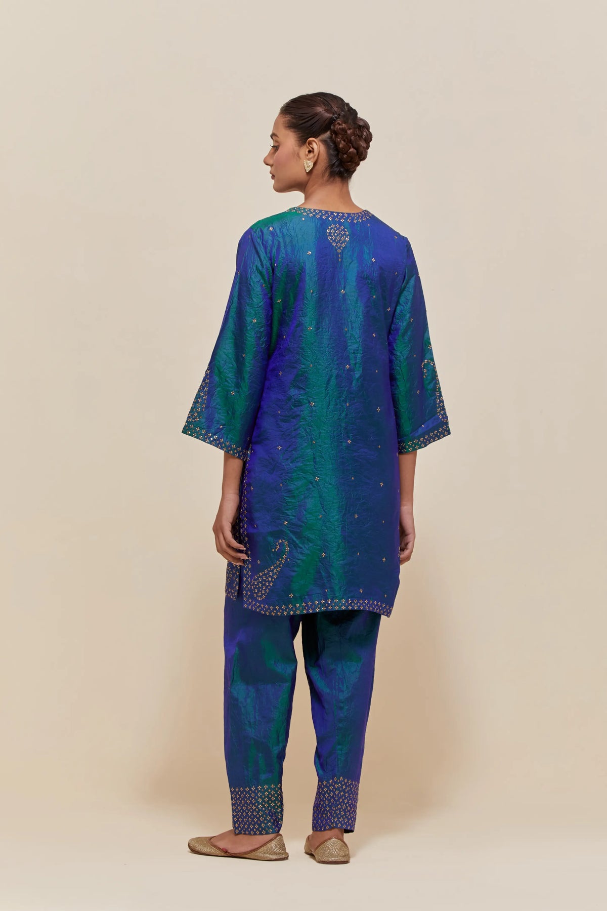 Teal blue silk straight short kurta set with hand-embroidered paisley motifs with delicate sequins work at neck, hem, and sleeves, with narrow borders along the edges.