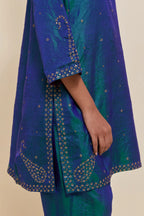 Teal blue silk straight short kurta set with hand-embroidered paisley motifs with delicate sequins work at neck, hem, and sleeves, with narrow borders along the edges.