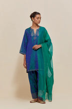 Teal blue silk straight short kurta set with hand-embroidered paisley motifs with delicate sequins work at neck, hem, and sleeves, with narrow borders along the edges.