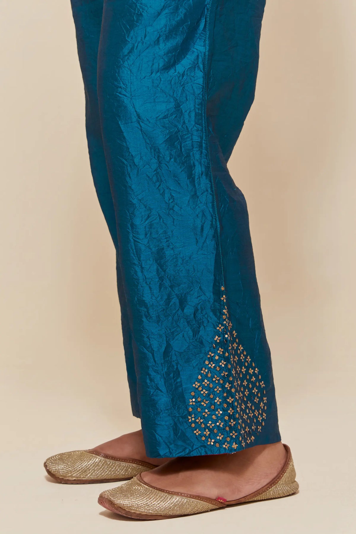 Teal Silk pants with hand embroidered leaf motifs with delicate sequins work at hem.