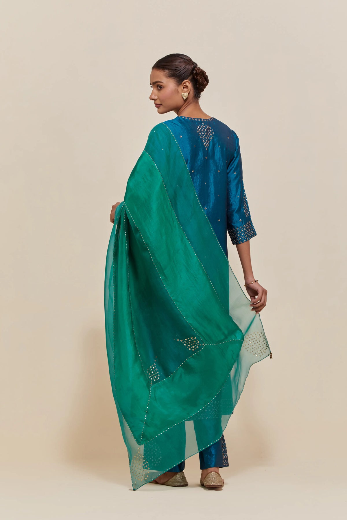 Green silk dupatta with silk organza at the sides, highlighted with hand-embroidered gold sequins work.