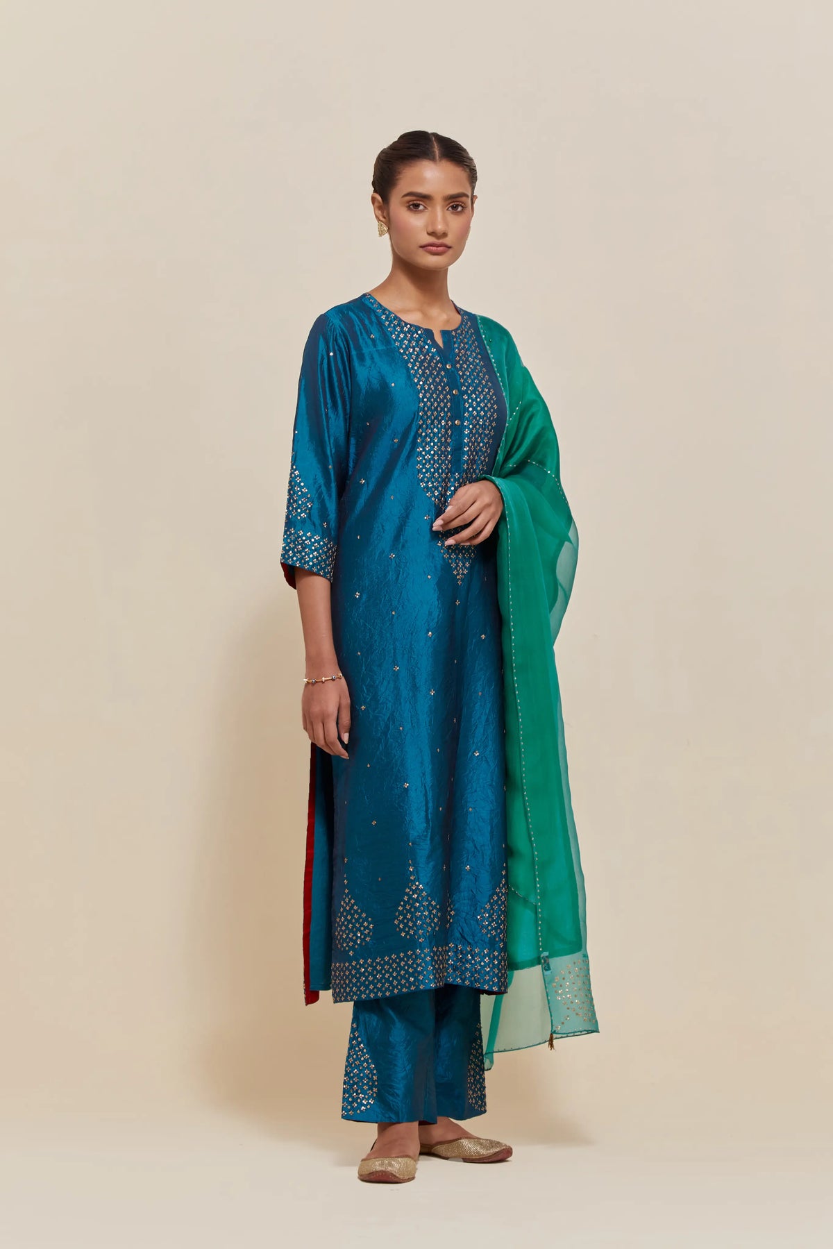 Green silk dupatta with silk organza at the sides, highlighted with hand-embroidered gold sequins work.