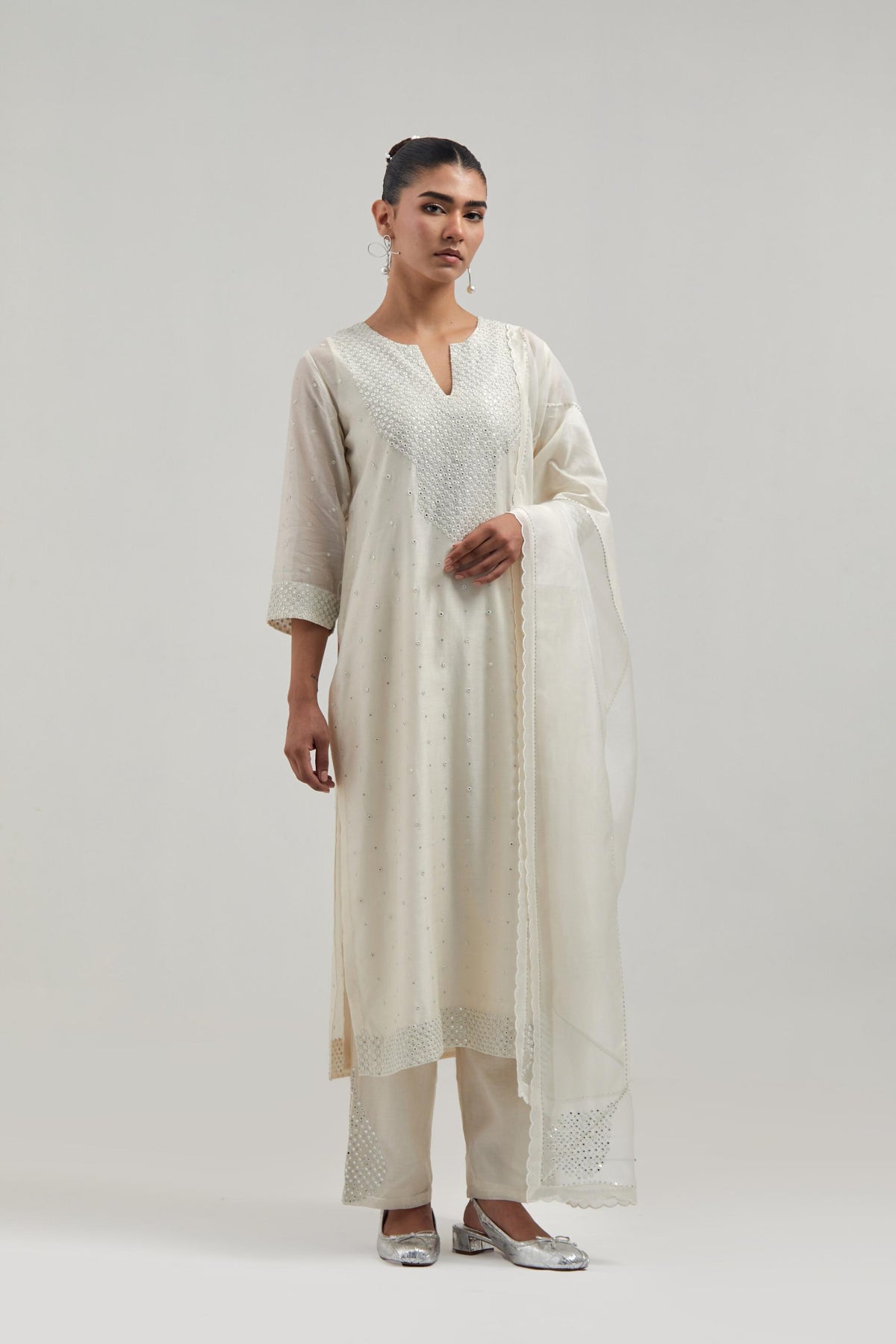 Off white silk Chanderi dupatta with silk organza at the sides, finished with delicate scalloped edges, highlighted by hand-embroidered mirror & sequins work.