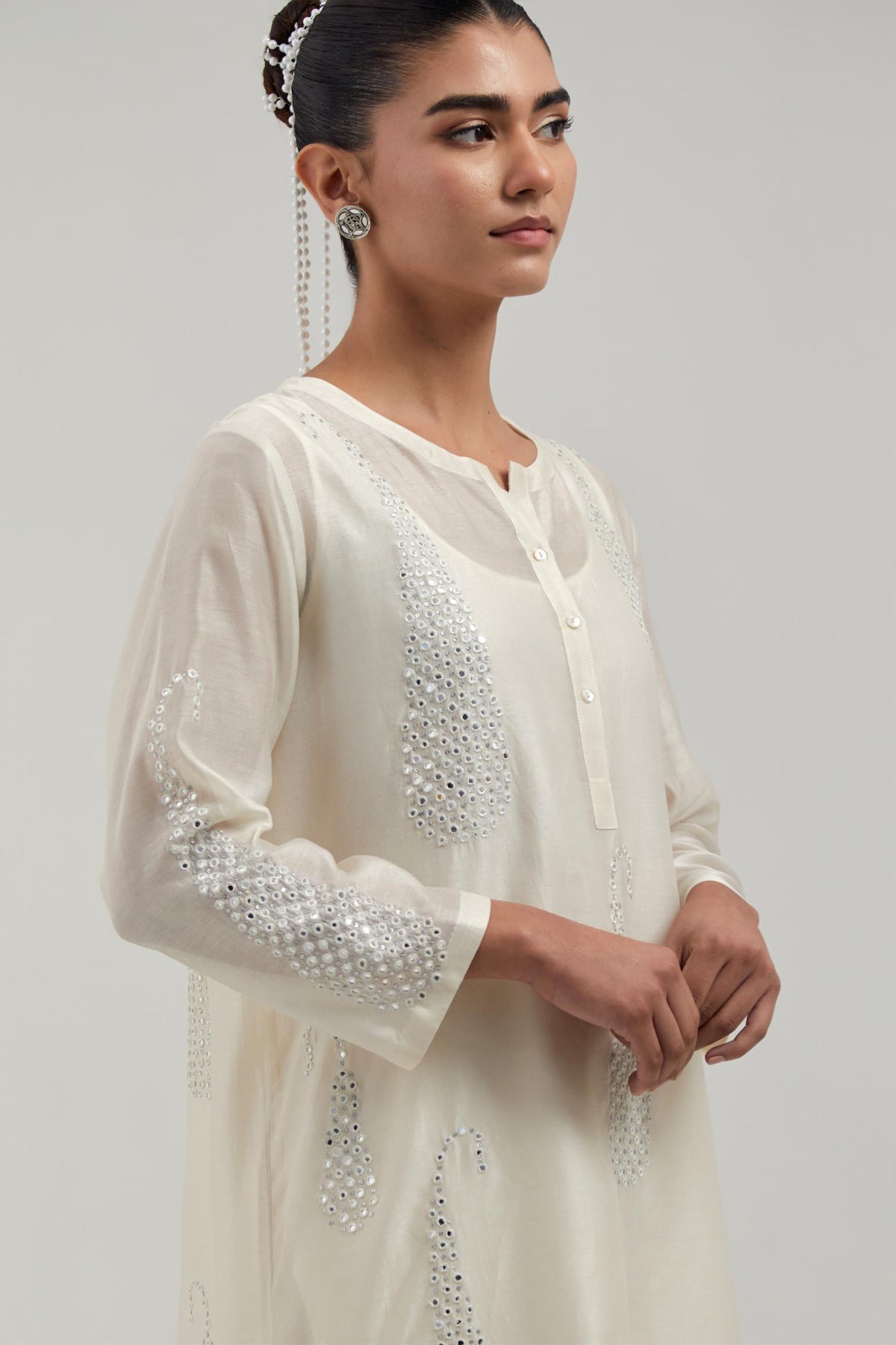 Off white Silk Chanderi short kurta set with hand-embroidered paisley motifs with delicate mirror and sequins work all-over the kurta.