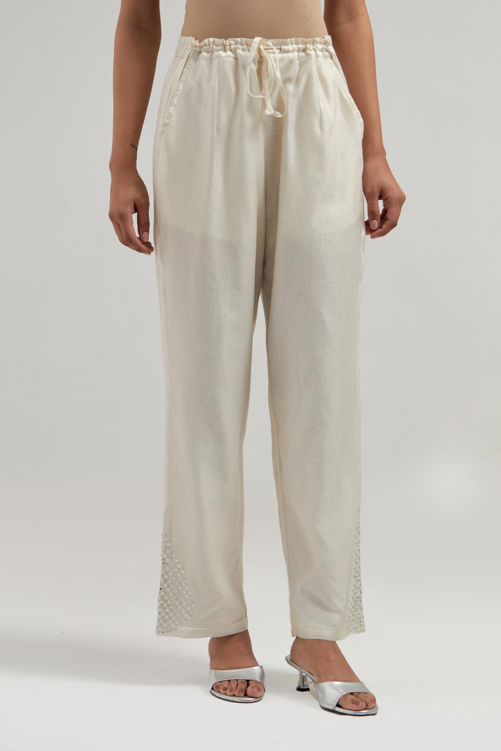 Off white Silk Chanderi pants with hand embroidered leaf motifs with delicate mirror & sequins work at hem.