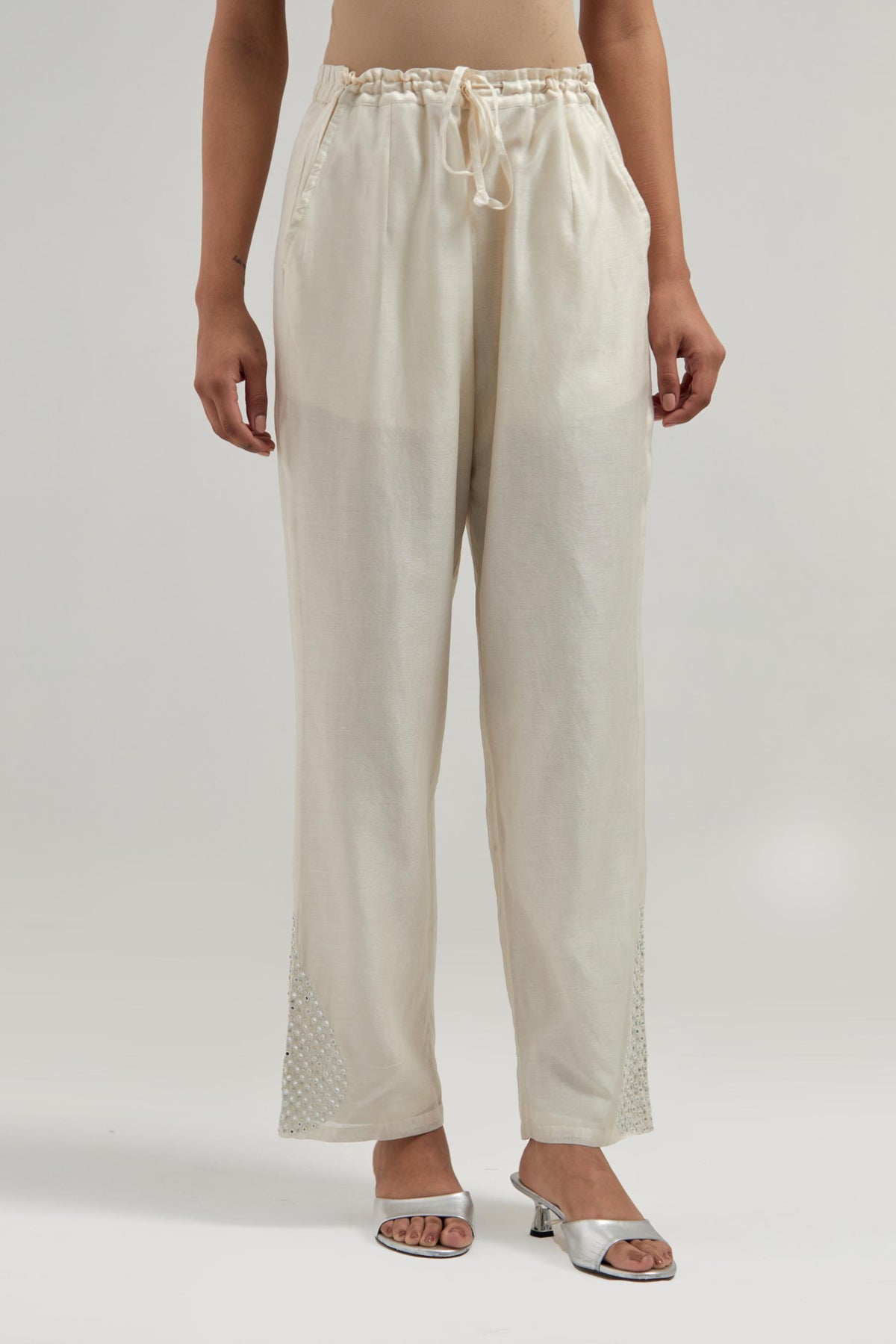 Off white Silk Chanderi pants with hand embroidered leaf motifs with delicate mirror & sequins work at hem.