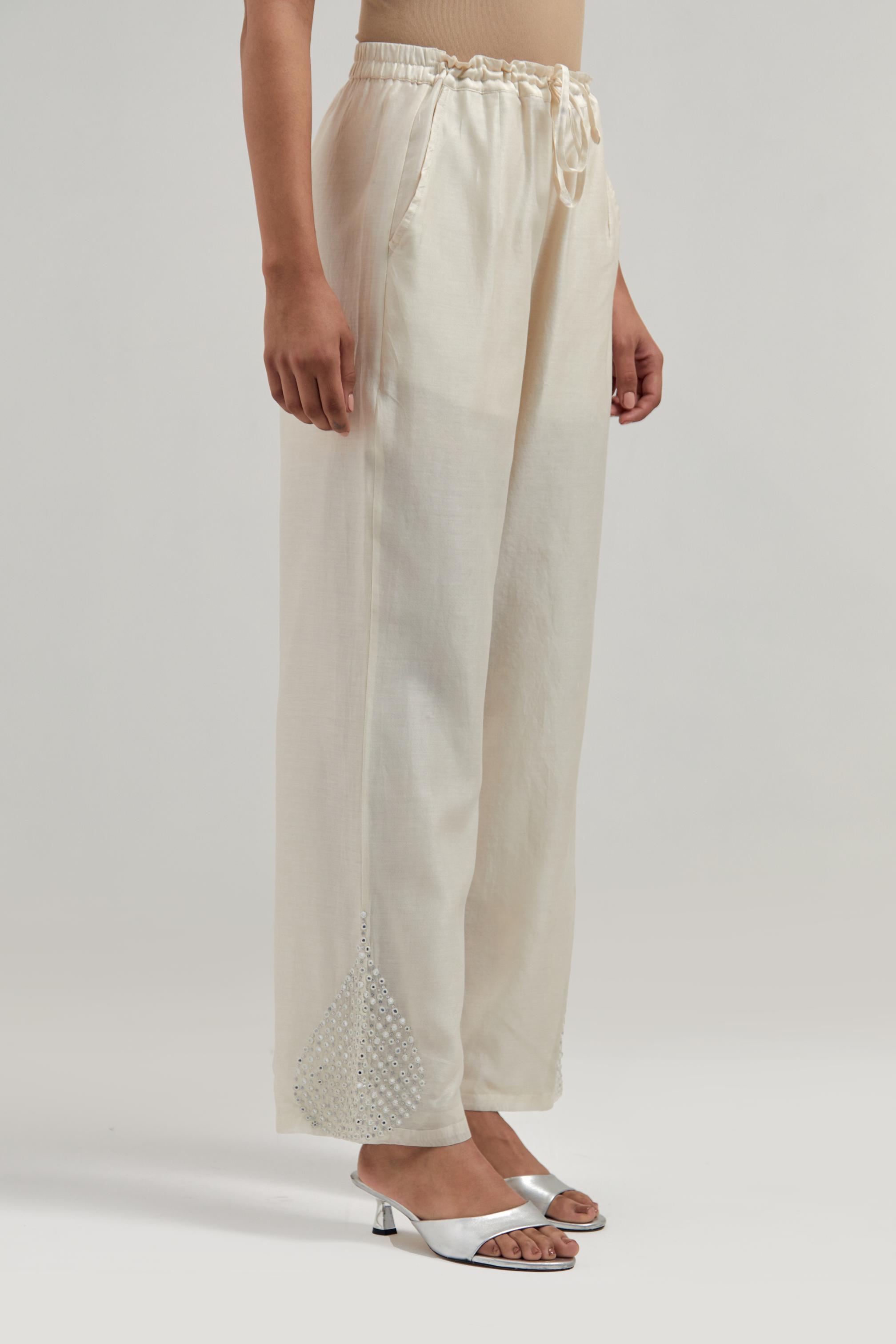Off white Silk Chanderi pants with hand embroidered leaf motifs with delicate mirror & sequins work at hem.