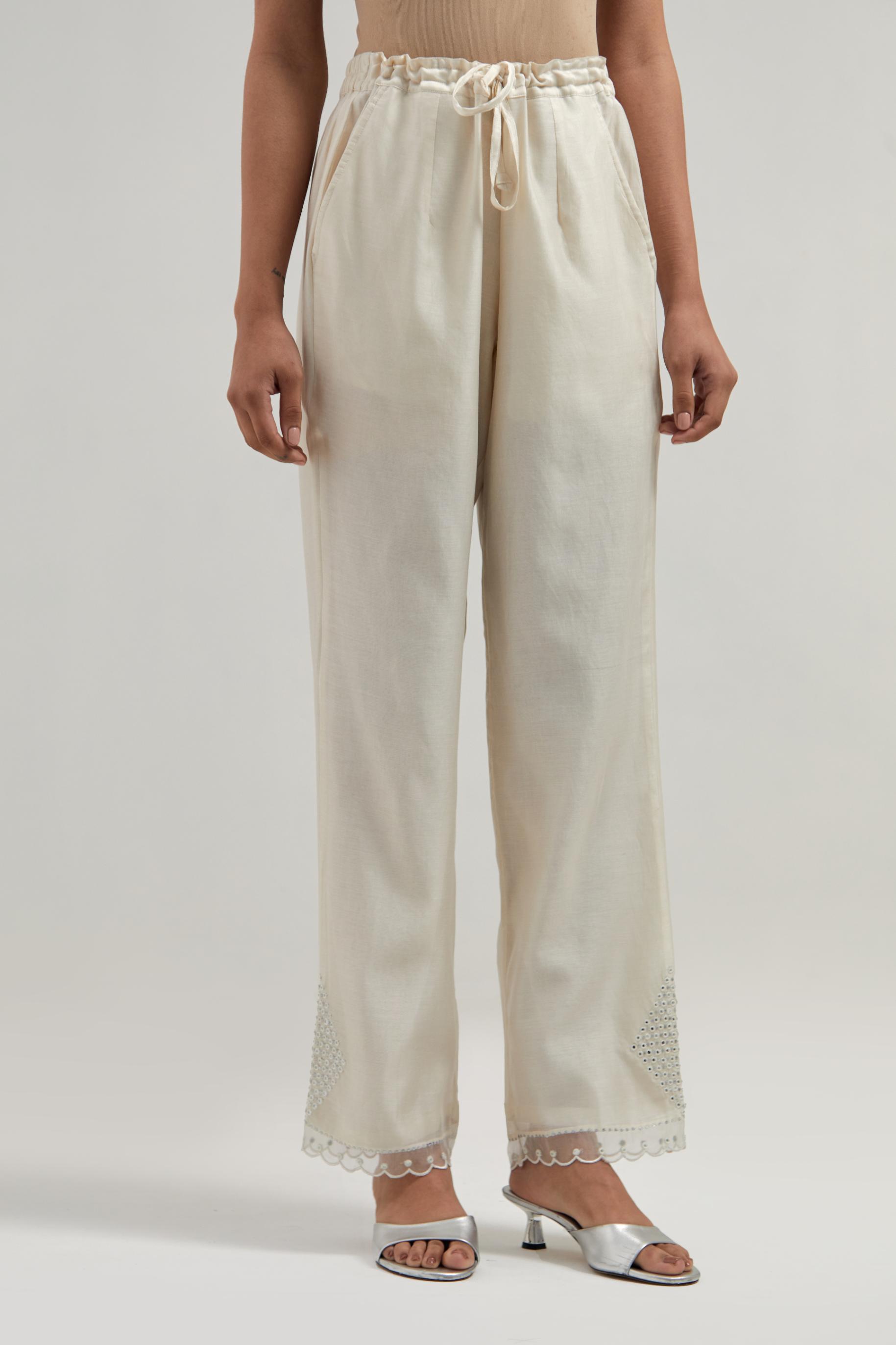 Off white silk Chanderi straight pants with narrow organza scalloped hem and hand-embroidered diamond motifs with delicate mirror & sequins work at the sides.