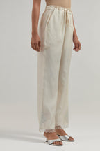 Off white silk Chanderi straight pants with narrow organza scalloped hem and hand-embroidered diamond motifs with delicate mirror & sequins work at the sides.