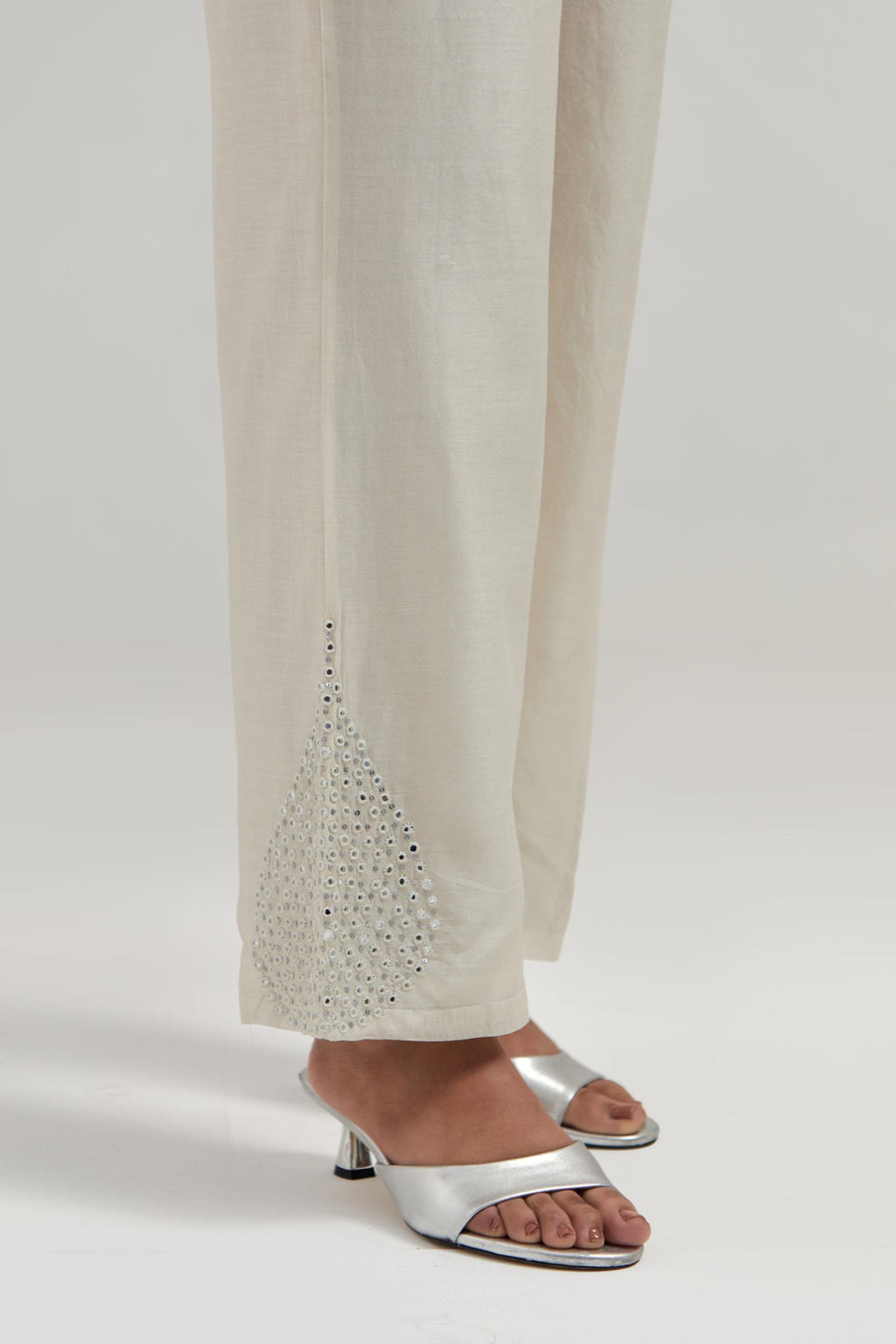 Off white Silk Chanderi pants with hand embroidered leaf motifs with delicate mirror & sequins work at hem.