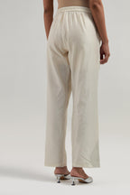 Off white Silk Chanderi pants with hand embroidered leaf motifs with delicate mirror & sequins work at hem.