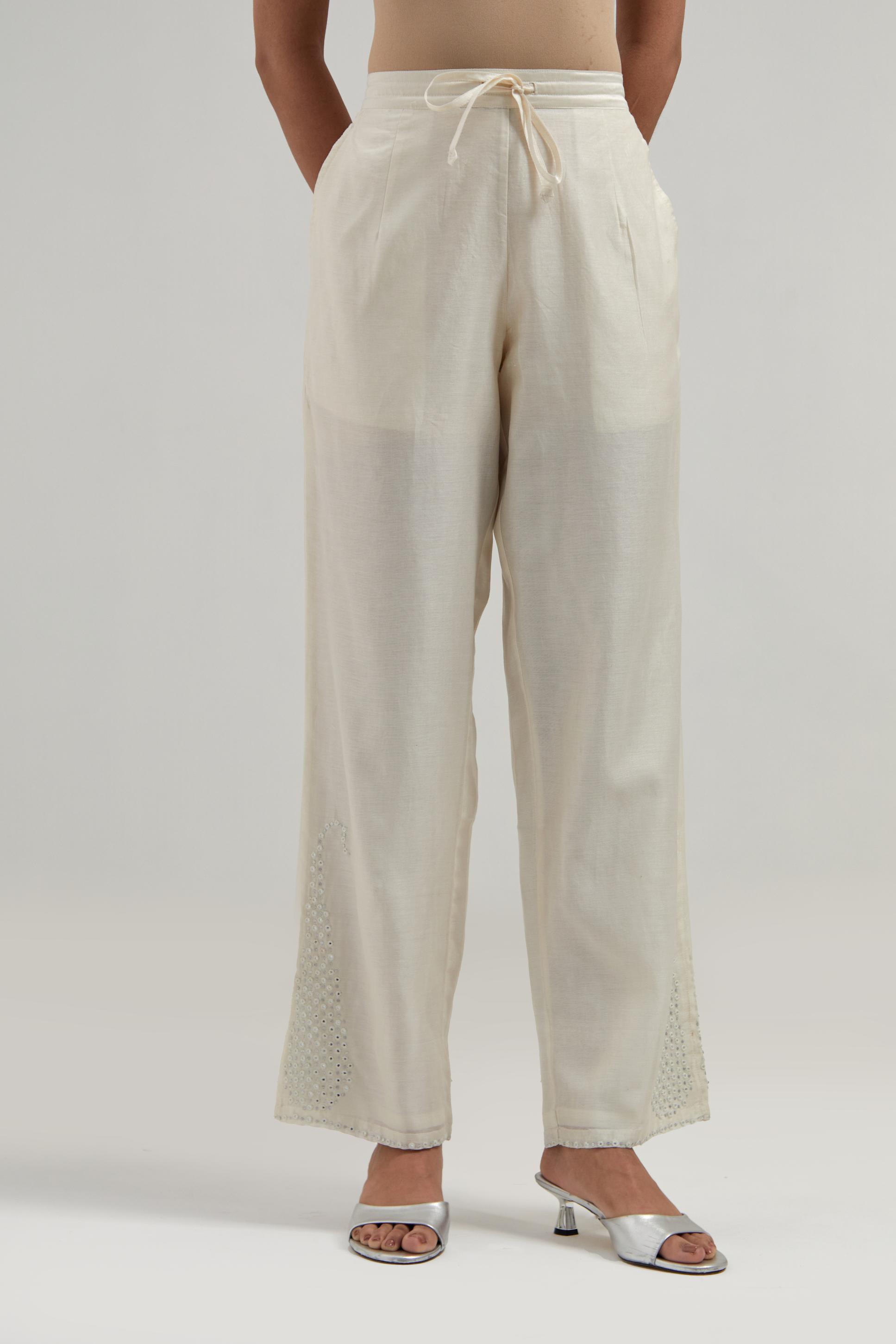 Off white silk Chanderi pants with hand-embroidered paisley motifs with delicate mirror and sequins work at the hem.