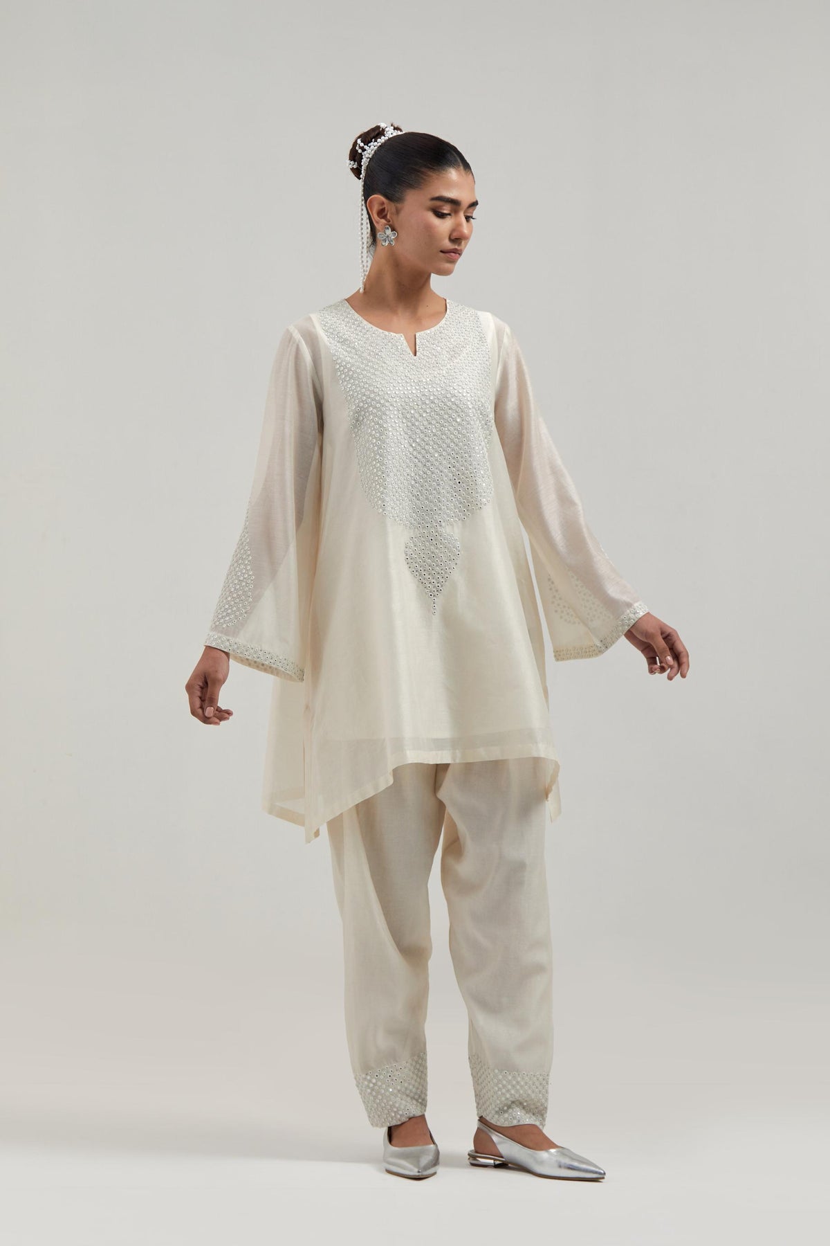 Off white silk Chanderi short A-line kurta set with hand-embroidered mirror work at the neck and bell sleeves.