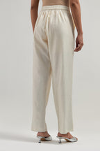 Off white silk Chanderi pants with hand-embroidered paisley motifs with delicate mirror and sequins work at the hem.