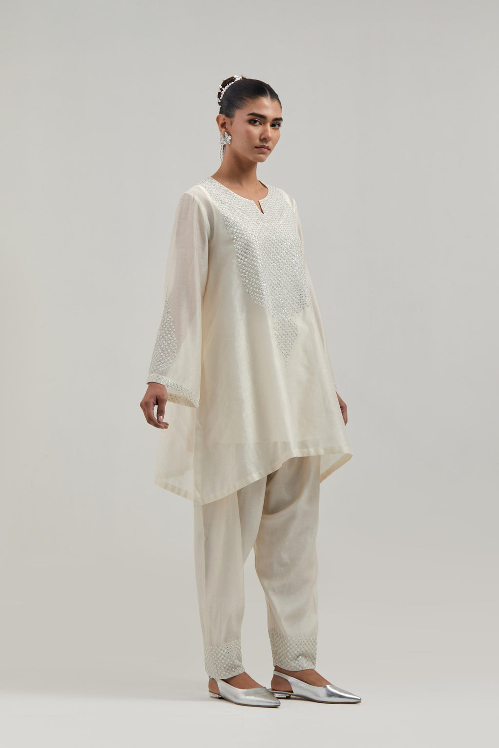 Off white silk Chanderi short A-line kurta set with hand-embroidered mirror work at the neck and bell sleeves.