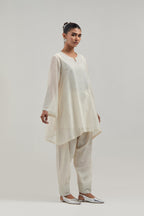 Off white silk Chanderi short A-line kurta set with hand-embroidered mirror work at the neck and bell sleeves.