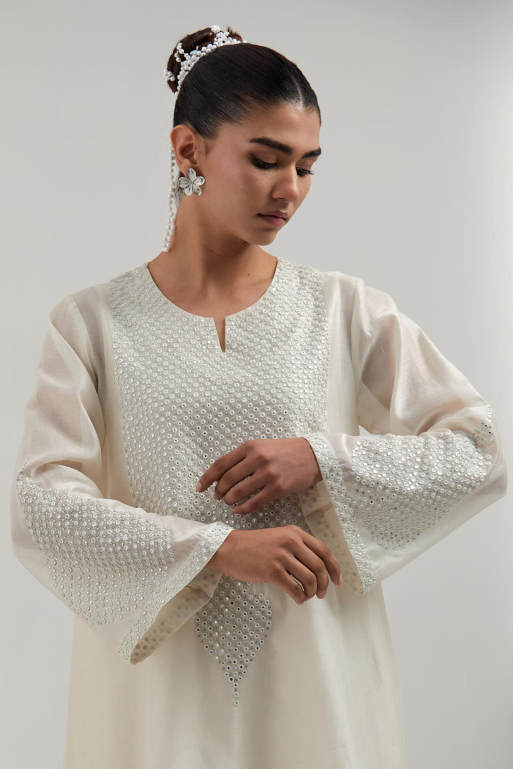 Off white silk Chanderi short A-line kurta set with hand-embroidered mirror work at the neck and bell sleeves.