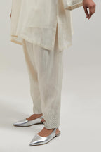 Off white silk Chanderi short A-line kurta set with hand-embroidered mirror work at the neck and bell sleeves.