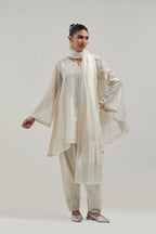Off white silk Chanderi short A-line kurta set with hand-embroidered mirror work at the neck and bell sleeves.