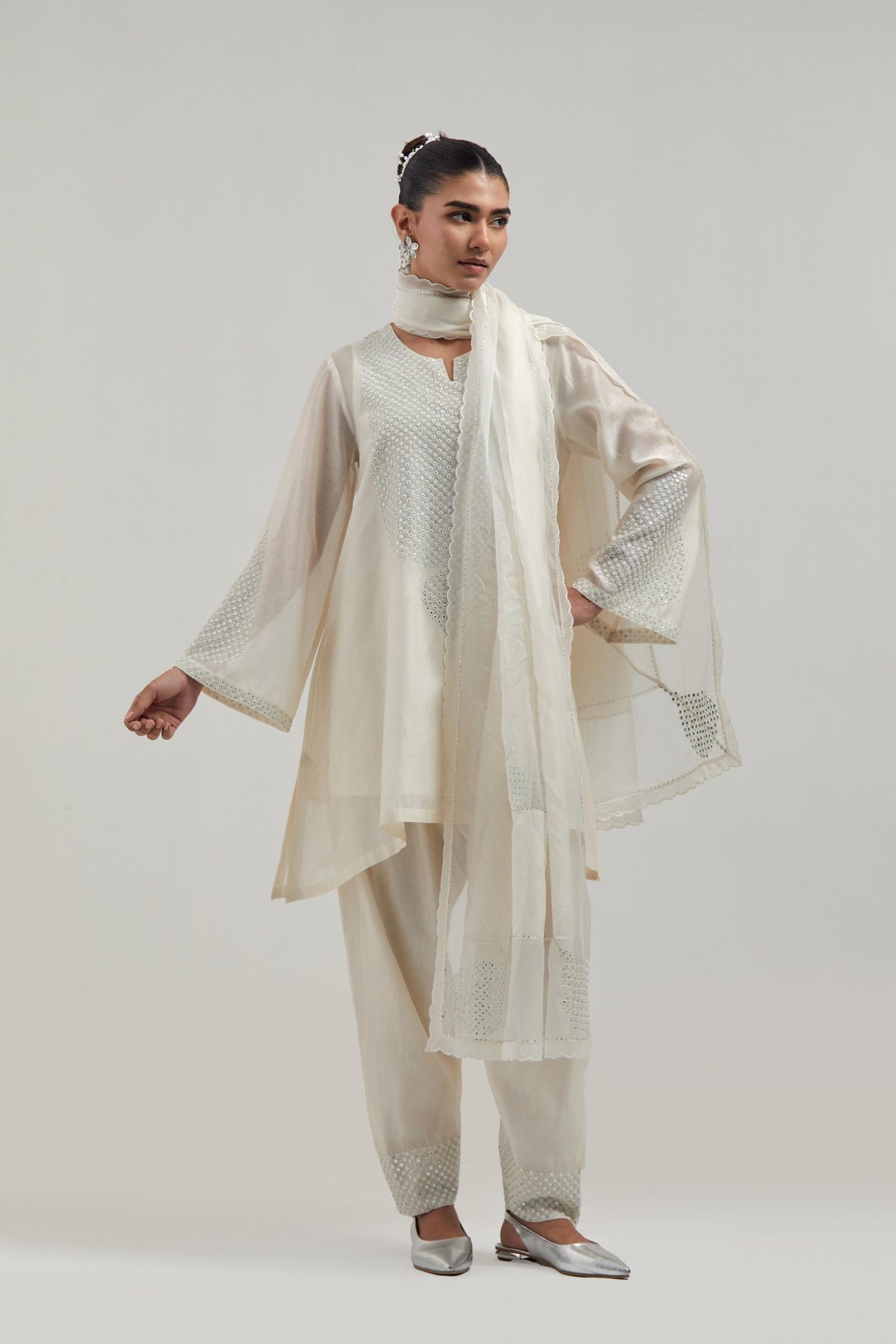 Off white silk Chanderi short A-line kurta set with hand-embroidered mirror work at the neck and bell sleeves.