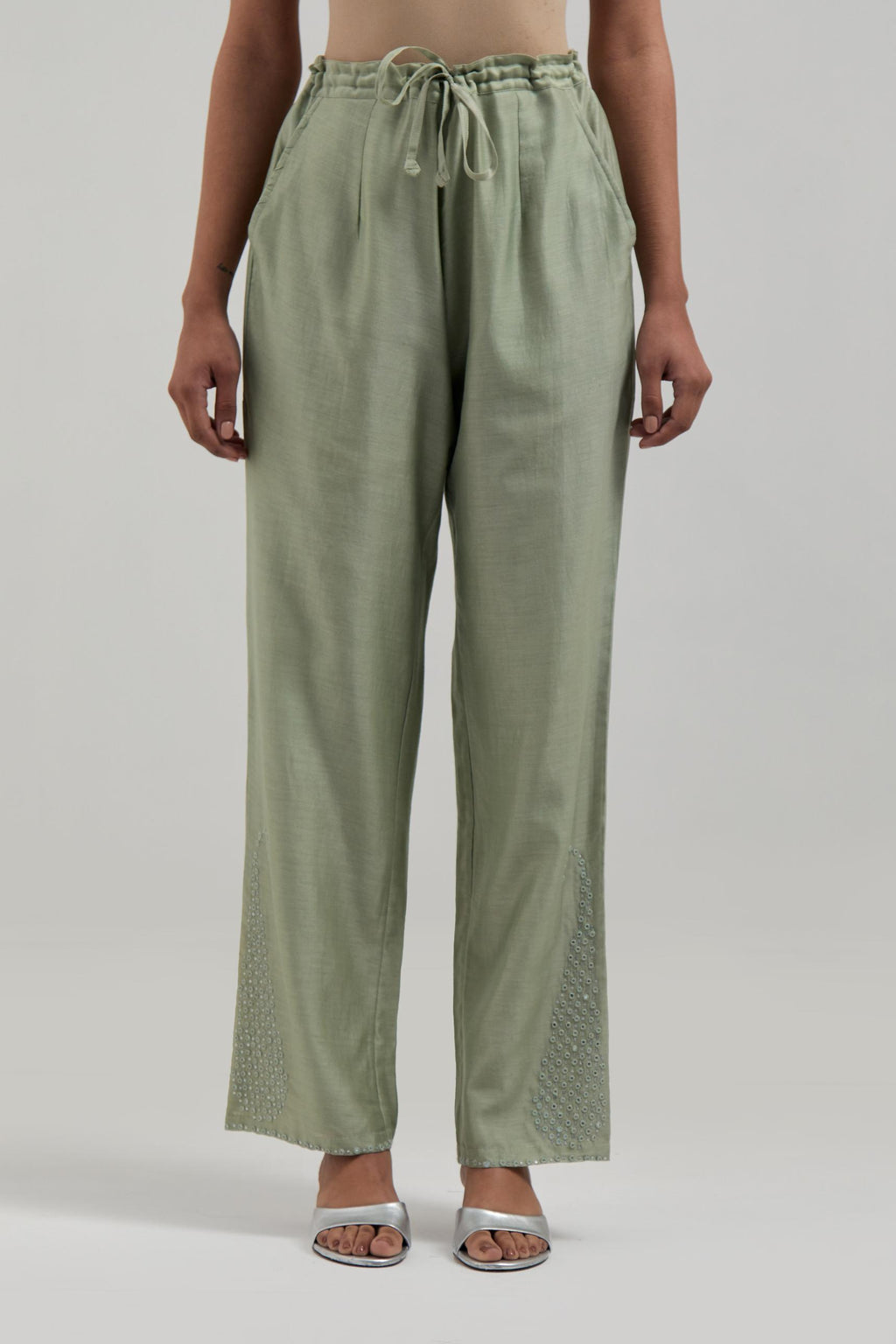 Green silk Chanderi pants with hand-embroidered paisley motifs with delicate mirror and sequins work at the hem.