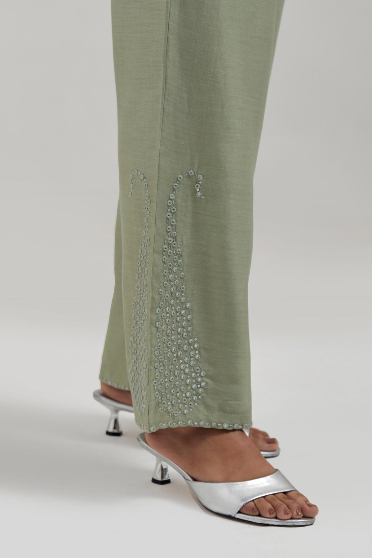 Green silk Chanderi pants with hand-embroidered paisley motifs with delicate mirror and sequins work at the hem.