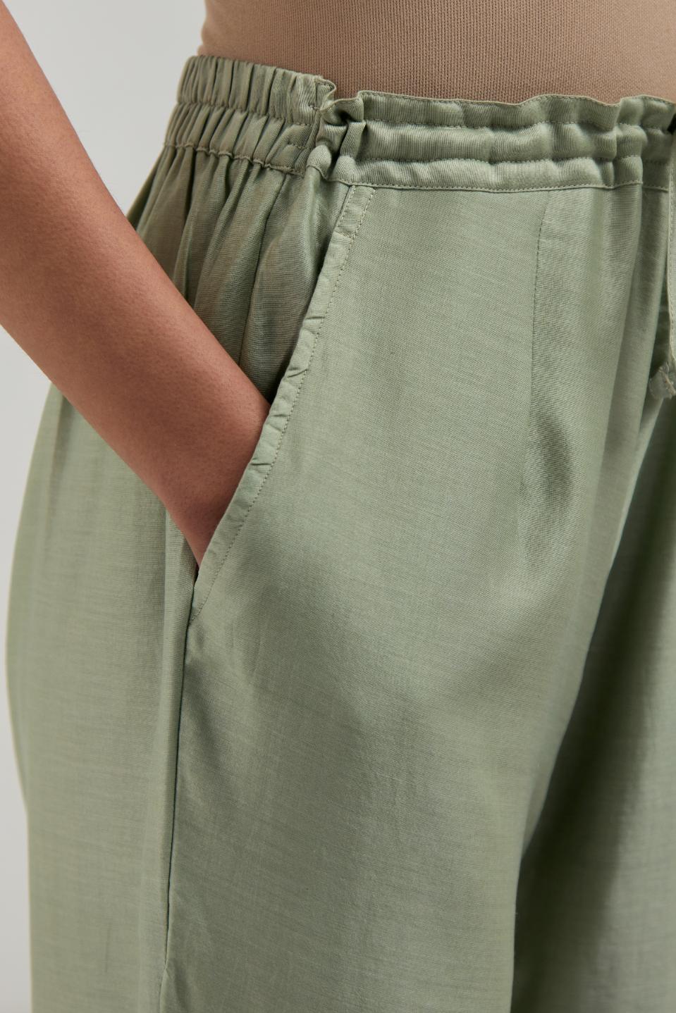 Green silk Chanderi pants with hand-embroidered paisley motifs with delicate mirror and sequins work at the hem.