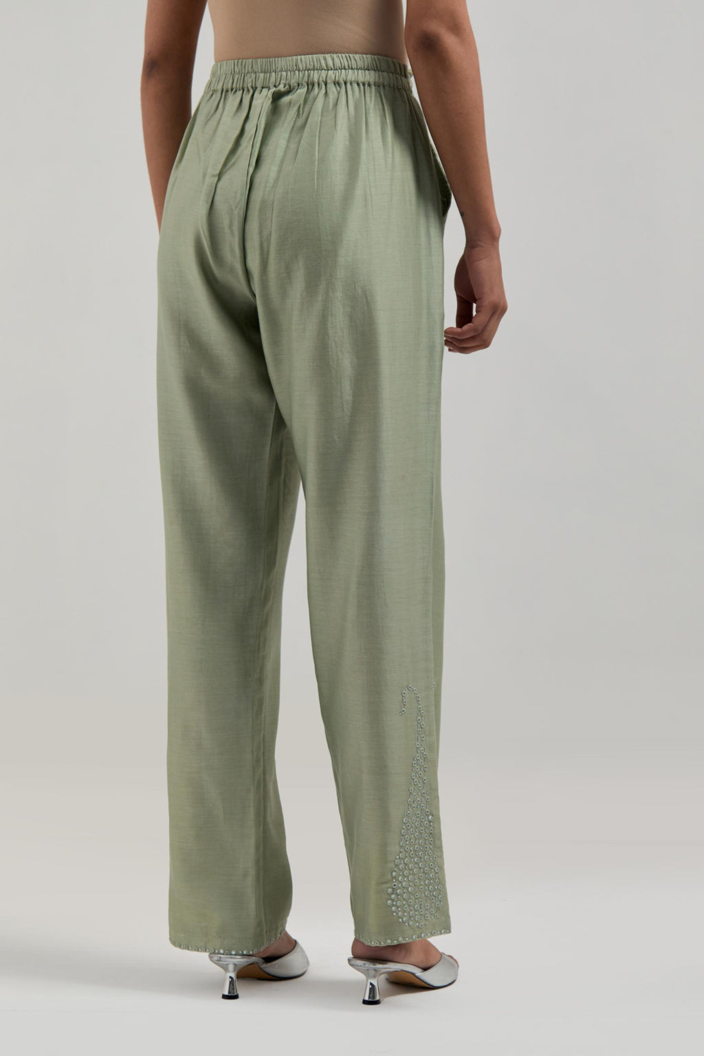Green silk Chanderi pants with hand-embroidered paisley motifs with delicate mirror and sequins work at the hem.