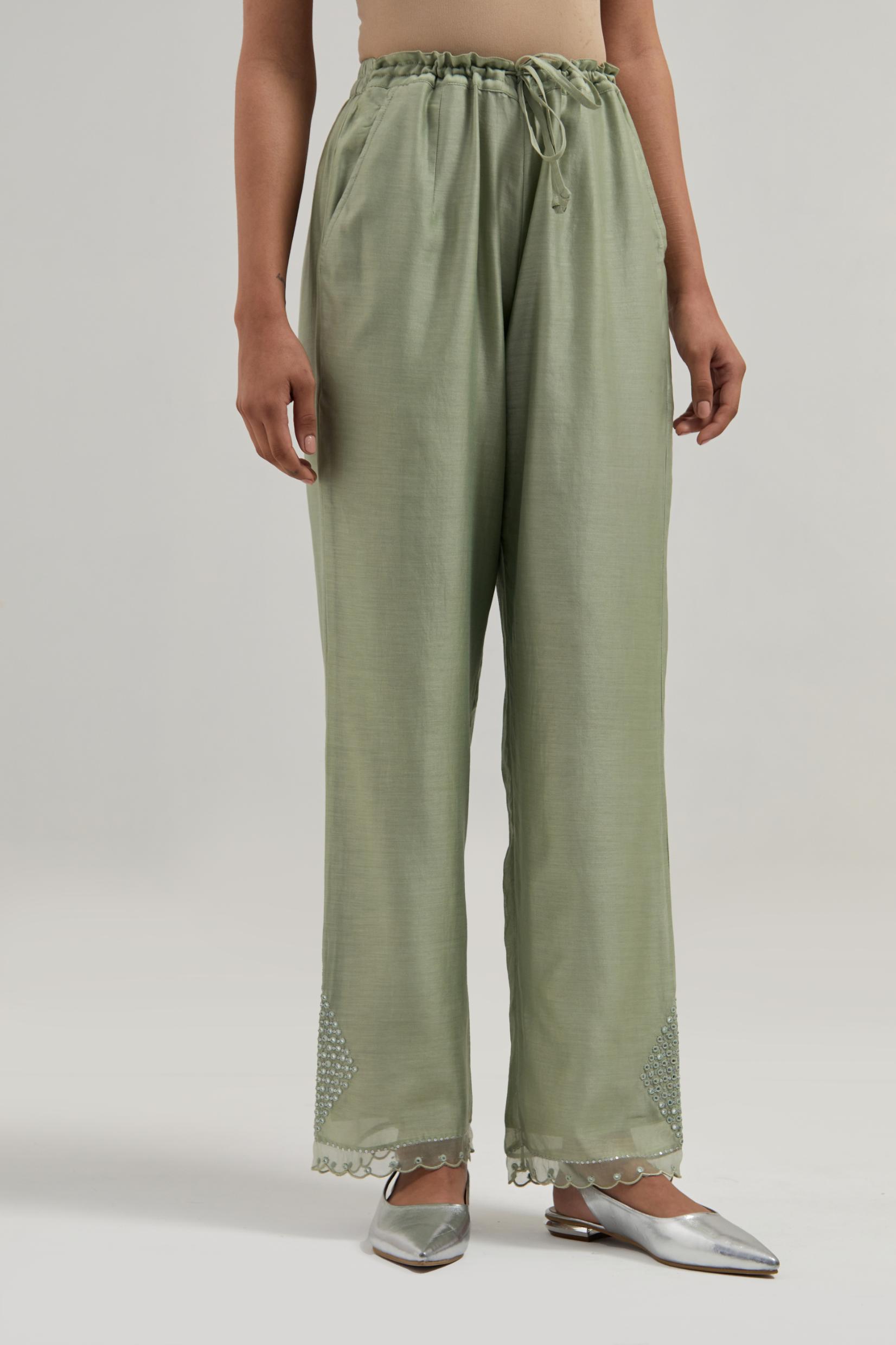 Green silk Chanderi straight pants with narrow organza scalloped hem and hand-embroidered diamond motifs with delicate mirror & sequins work at the sides.