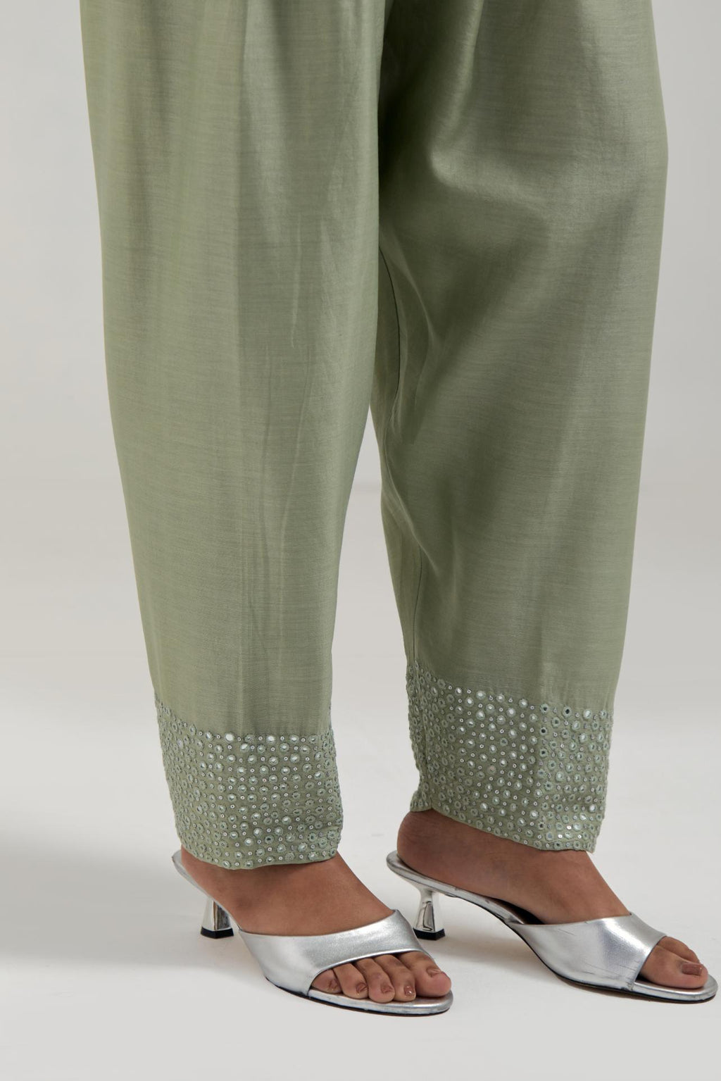 Green silk Chanderi salwar with hand-embroidered mirror & sequins work in a broad border at the hem.