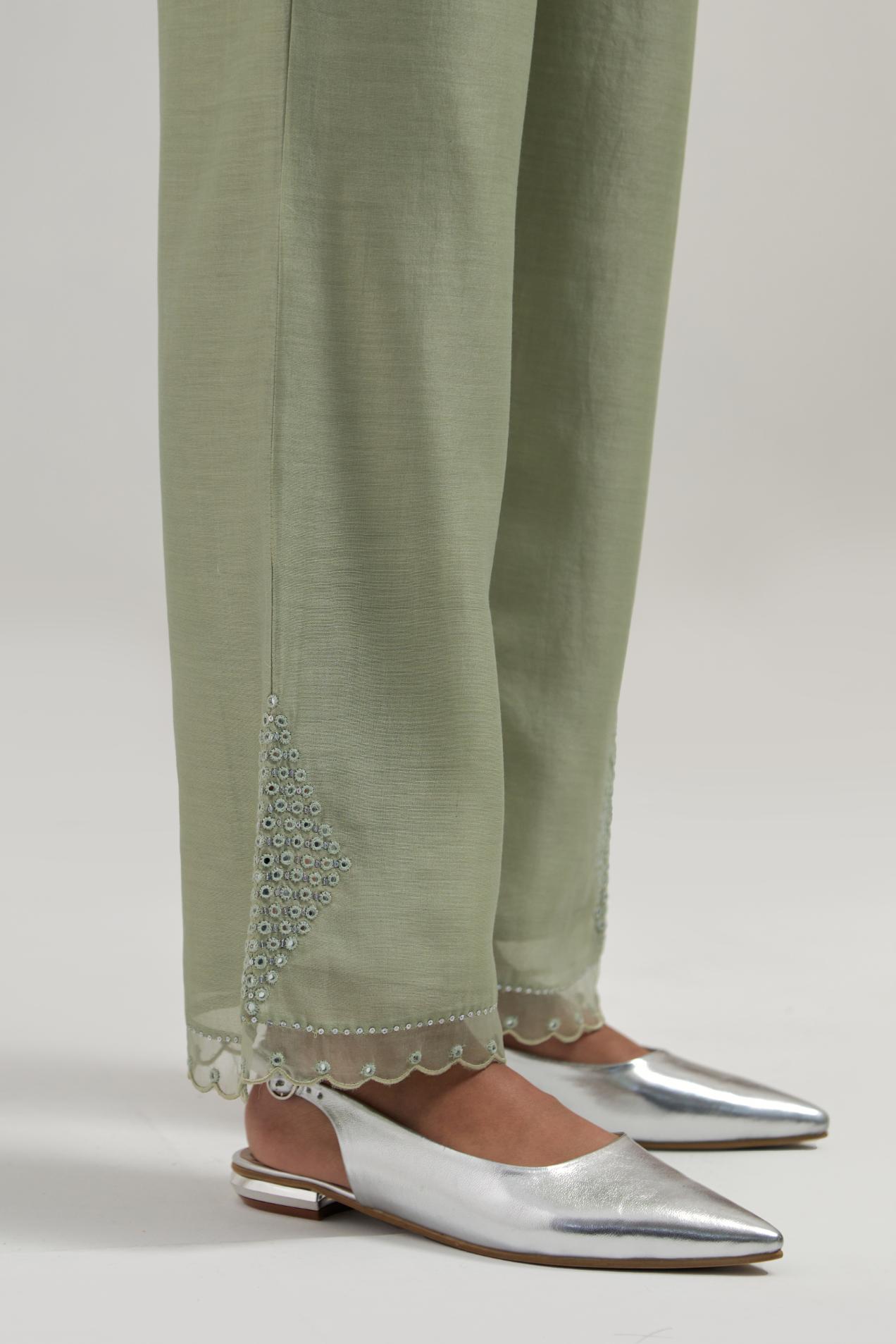 Green silk Chanderi straight pants with narrow organza scalloped hem and hand-embroidered diamond motifs with delicate mirror & sequins work at the sides.