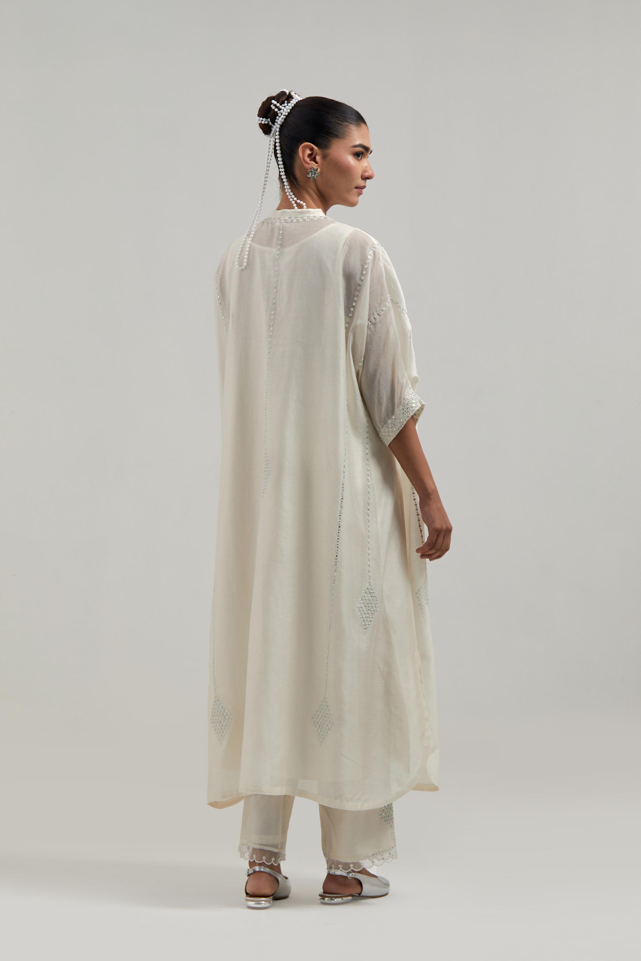 Off white silk Chanderi long kaftan with hand-embroidered mirror and sequins at the neck and diamond motifs along the sides, paired with Off white silk Chanderi straight pants with narrow organza scalloped hem and hand-embroidered diamond motifs.