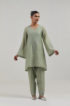 Green silk Chanderi short A-line kurta set with hand-embroidered mirror work at the neck and bell sleeves.