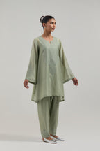 Green silk Chanderi short A-line kurta set with hand-embroidered mirror work at the neck and bell sleeves.