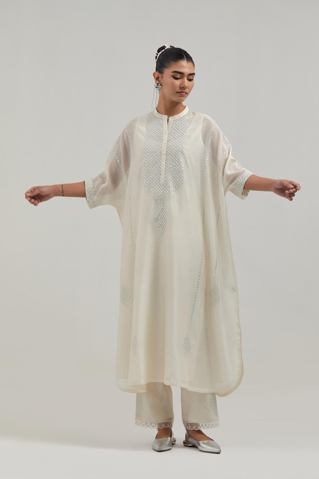 Off white silk Chanderi long kaftan with hand-embroidered mirror and sequins at the neck and diamond motifs along the sides, paired with Off white silk Chanderi straight pants with narrow organza scalloped hem and hand-embroidered diamond motifs.