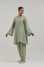 Green silk Chanderi short A-line kurta set with hand-embroidered mirror work at the neck and bell sleeves.