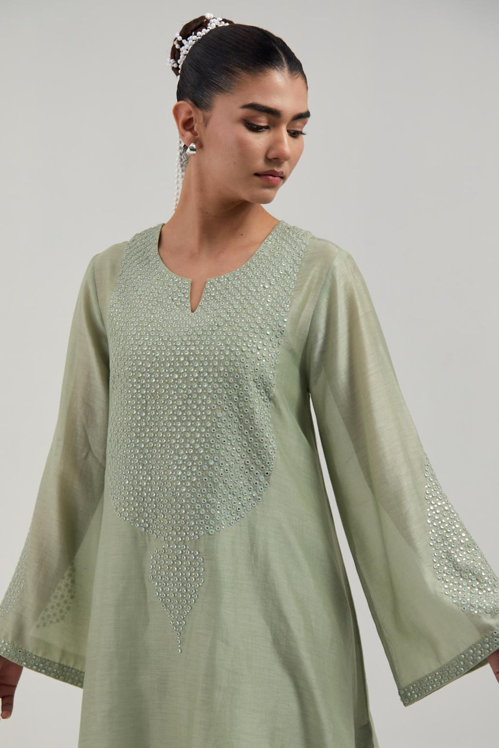 Green silk Chanderi short A-line kurta set with hand-embroidered mirror work at the neck and bell sleeves.