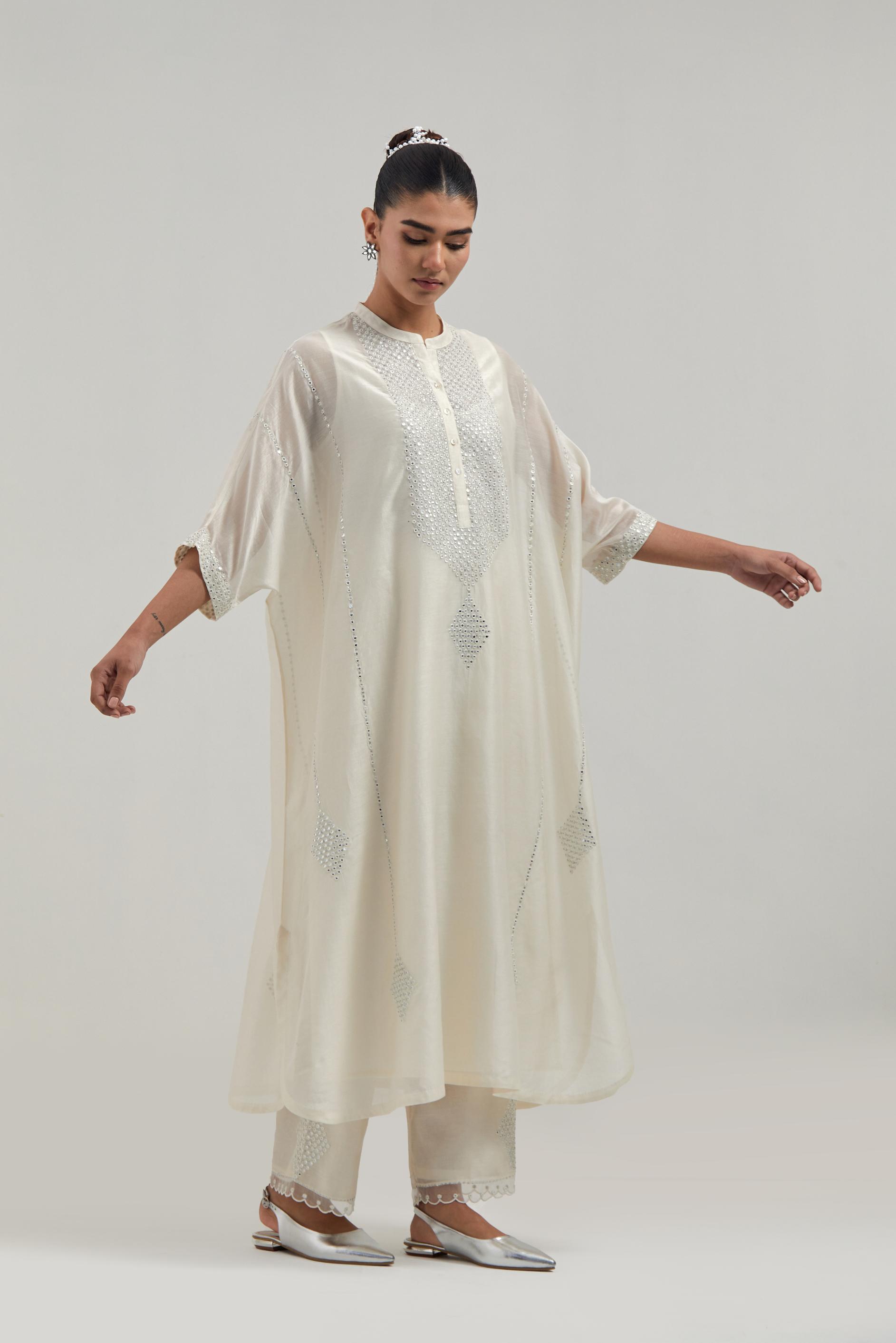 Off white silk Chanderi long kaftan with hand-embroidered mirror and sequins at the neck and diamond motifs along the sides, paired with Off white silk Chanderi straight pants with narrow organza scalloped hem and hand-embroidered diamond motifs.