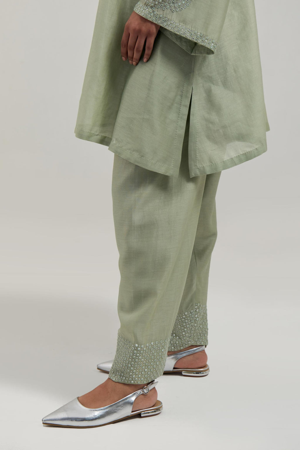 Green silk Chanderi short A-line kurta set with hand-embroidered mirror work at the neck and bell sleeves.