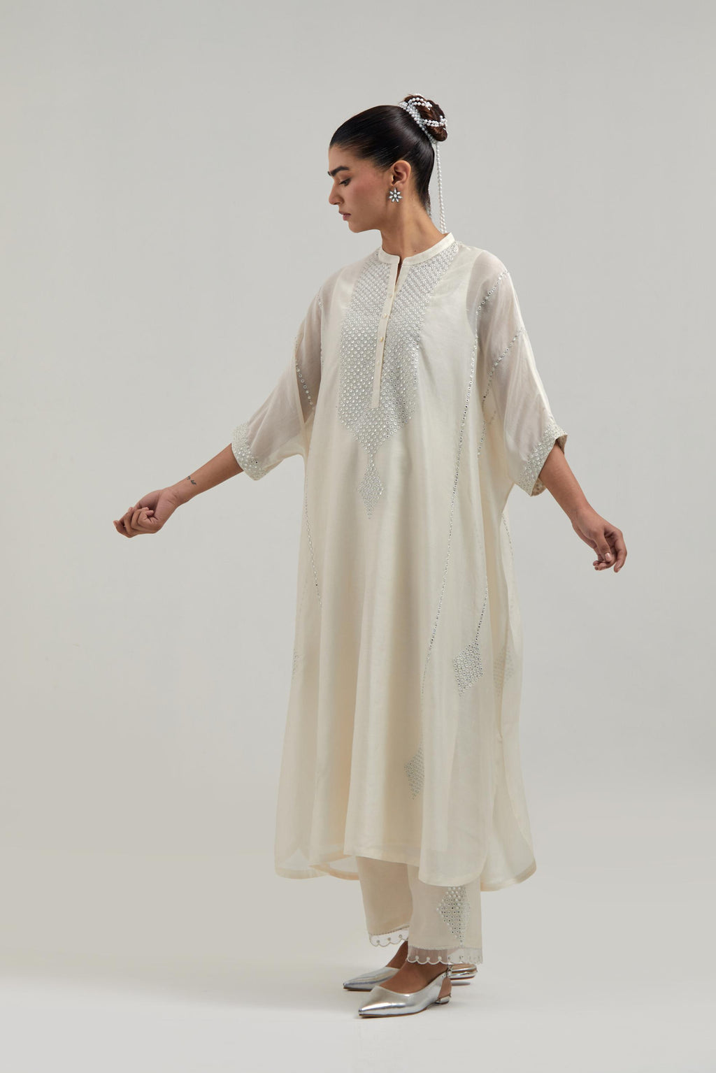 Off white silk Chanderi long kaftan with hand-embroidered mirror and sequins at the neck and diamond motifs along the sides, paired with Off white silk Chanderi straight pants with narrow organza scalloped hem and hand-embroidered diamond motifs.