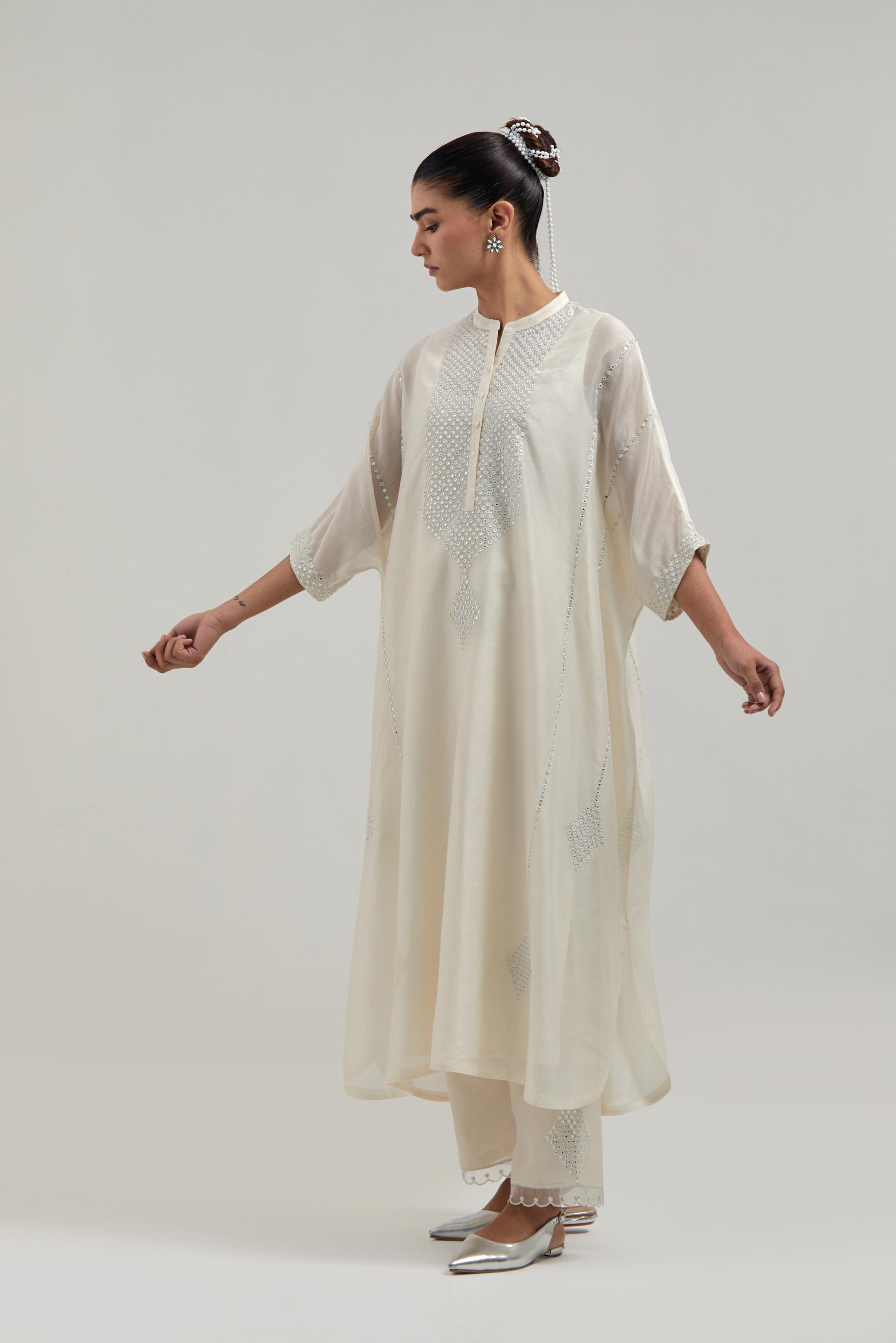 Off white silk Chanderi long kaftan with hand-embroidered mirror and sequins at the neck and diamond motifs along the sides, paired with Off white silk Chanderi straight pants with narrow organza scalloped hem and hand-embroidered diamond motifs.