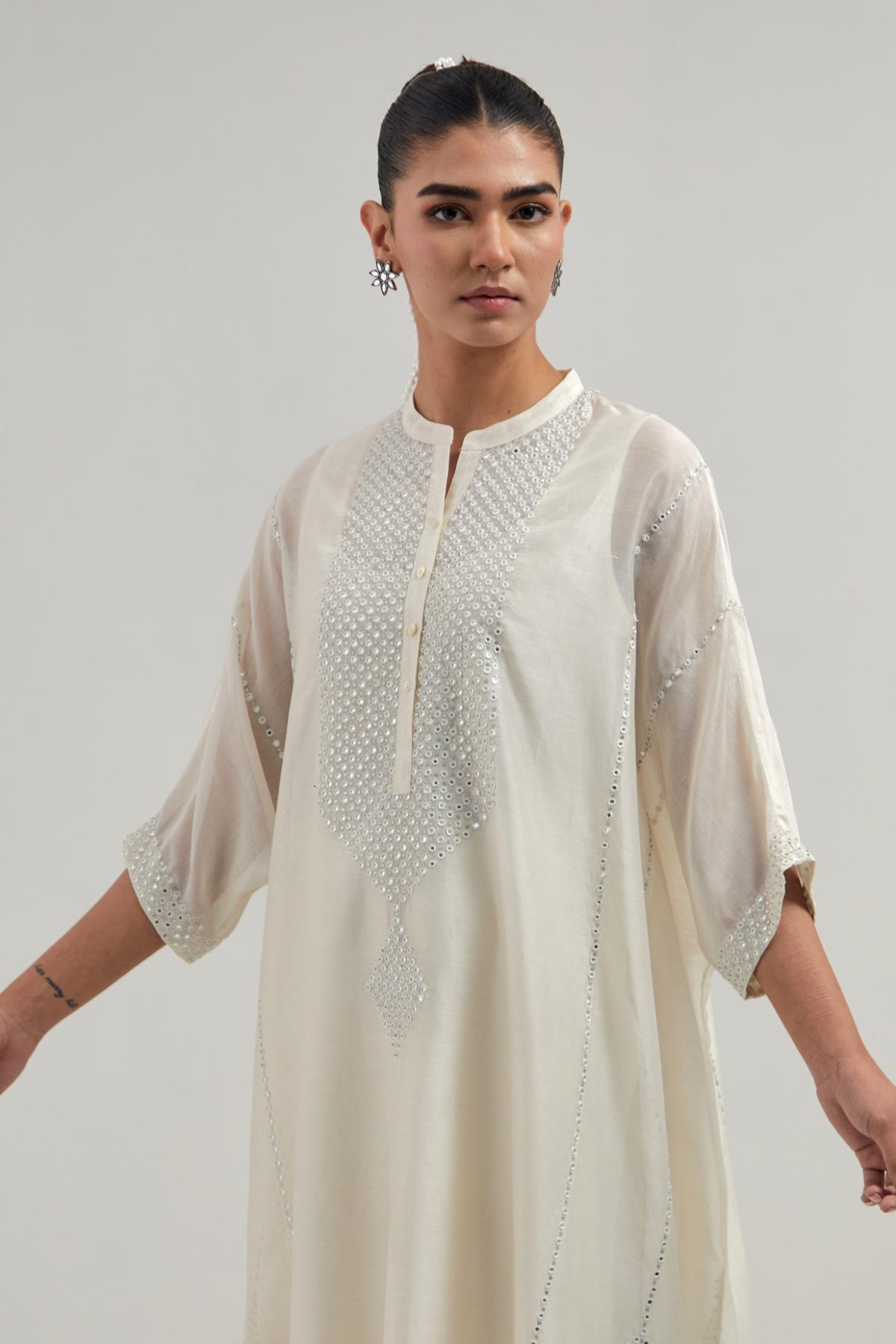 Off white silk Chanderi long kaftan with hand-embroidered mirror and sequins at the neck and diamond motifs along the sides, paired with Off white silk Chanderi straight pants with narrow organza scalloped hem and hand-embroidered diamond motifs.