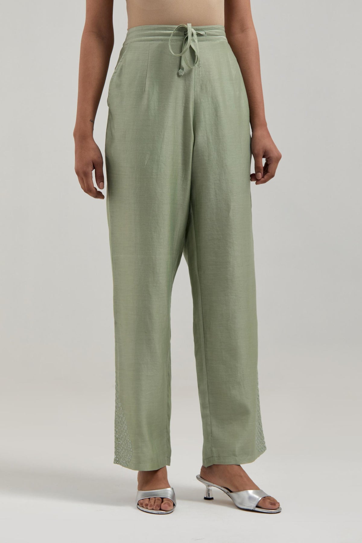 Green Silk Chanderi pants with hand embroidered leaf motifs with delicate mirror & sequins work at hem.