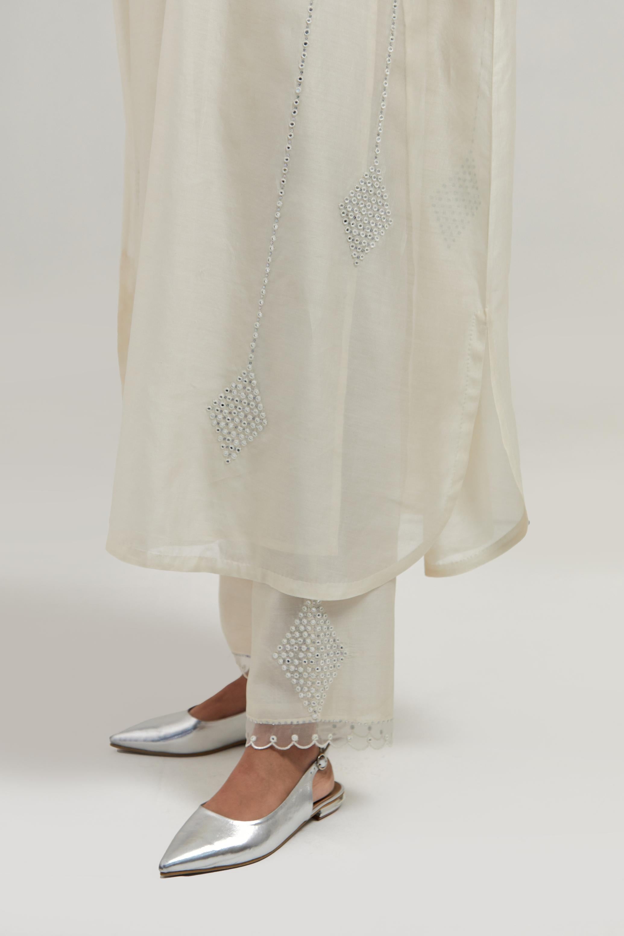 Off white silk Chanderi long kaftan with hand-embroidered mirror and sequins at the neck and diamond motifs along the sides, paired with Off white silk Chanderi straight pants with narrow organza scalloped hem and hand-embroidered diamond motifs.