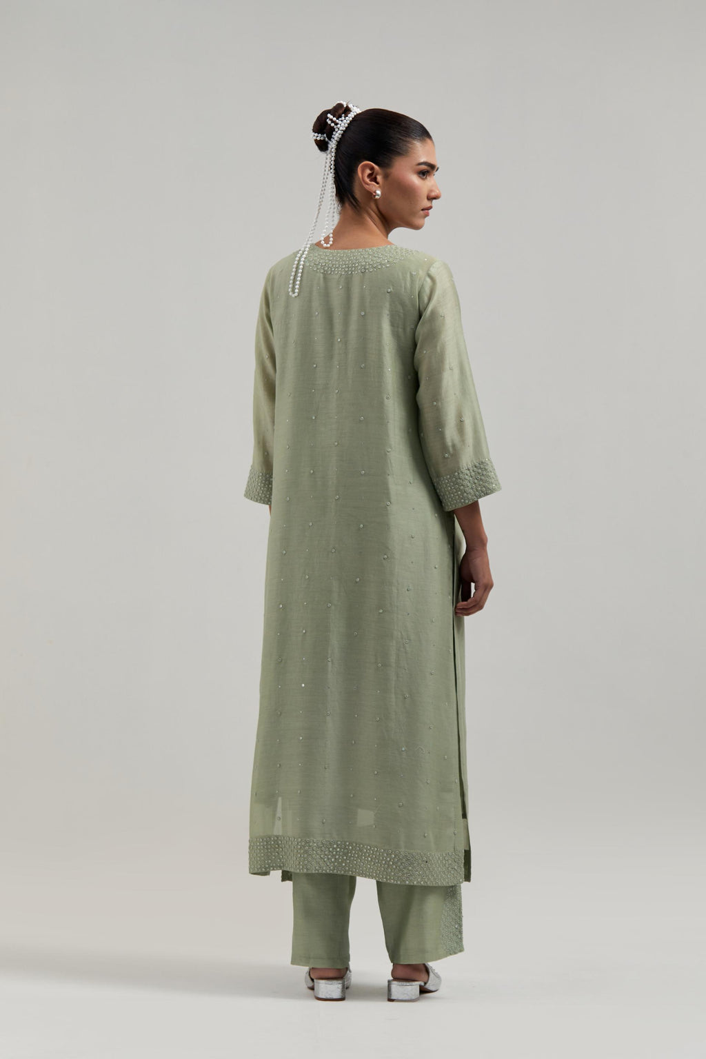 Green silk Chanderi straight kurta set with hand-embroidered mirror at the neck, hem and sleeves, highlighted with scattered silver sequin and mirror embellishments all-over.